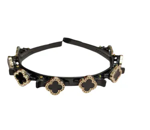 Hovedbilde H&aring;rb&oslash;yle med klips,  sort pynt med gullfarget kant 